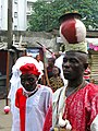 A man carrying a burning pot on his head as part of a procession in a residential area of Lagos. Probably a member of Eyo Iga Etti.