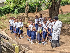 Eine Schulklasse wartet darauf, dass eine Lehrerin ihre in Kinyarwanda verfassten Texte korrigiert