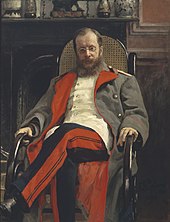 Portrait of a man with a long beard and glasses, wearing a military uniform and sitting in a rocking chair