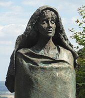 A bronze statue of a hooded woman, Hildegard of Bingen