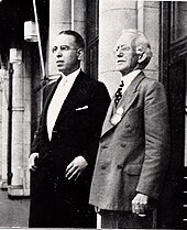 Profile shot of two men in suits; Zerbe on right