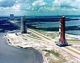 An aerial view of the Apollo 4 rocket before its launch, with the Vehicle Assembly Building visible in the background
