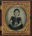Girl in mourning dress holding framed photograph of her father, USA, encased, c. 1861–1870