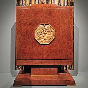 Art Deco octagon-shaped medallion on a makeup cabinet, medallion by Alfred Janniot and cabinet by Jacques-Émile Ruhlmann, c.1929, varnished American walnut, gilded bronze and light oak interior, in a temporary exhibition called "1925, quand l'Art Déco séduit le monde" at the Architecture and Heritage City, Paris