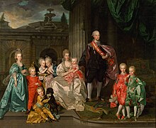 A family seated/stood towards the viewer. The women are wearing stays and hoop skirts with close-bodied, low-necked gowns. They wear their hair in high rolls, powdered white. The men are wearing coats, waistcoats and white breeches. On the laft stands a 9-year-old girl in blue, holding the hand of a 6-year-old by in bright red. Before them sits a 4-year-old boy in yellow, with a light blue belt, playing with a black dog. Behind them, in a golden-and-green chair sits a 2-year-old boy in a long, light pink dress. He and a 5-year-old girl in blue are playing with a white dove. Then, a middle-aged woman sits in a white dress, holding an infant in red, Joseph. Next to them is a man wearing black, standing, and two blonde boys, one in red silk, the other in light green, holding hands.