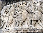 The relief on the Noyon war memorial commemorating the re-entry of the 13th Army Corps on 18 March 1917