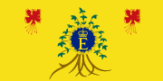 A yellow flag with flowers in both upper corners and a royal monogram logo in the center, surrounded by a plant.