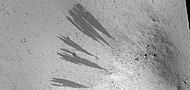 Dark slope streaks, as seen by HiRISE under HiWish program Shapes of streaks have been affected by boulders.
