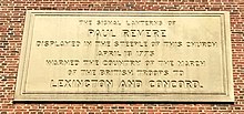 Photo of inscription on the side of the church which reads "The signal lanterns of Paul Revere displayed in the steeple of this church, April 18, 1775, warned the country of the march of the British Troops to Lexington and Concord."