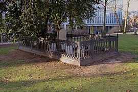 A rectangular area of about 3 by 7 meters with gravestones fenced in with an cast iron railing about a meter high