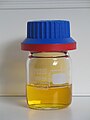 a small capped jar partly filled with an amber colored liquid