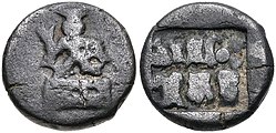 Coin of the Panchalas of Ahichhatra (75-50 BCE). Obv Indra seated facing on pedestal, holding bifurcated object. Rev Idramitrasa in Brahmi, Panchala symbols.