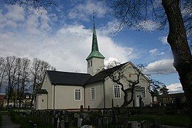Foto einer weißen Holzkirche, das Dach des Kirchturms ist grün