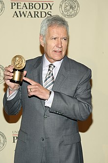 A shot of Alex Trebek holding an award