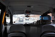 The division in a London cab, black occasional seats folded up to bulkhead