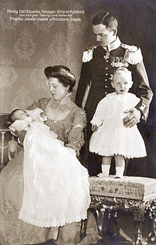 A couple in early 20th century dress with two infant children