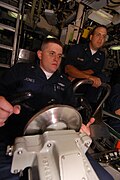 YN3 Joshua Jones, helmsman of the watch, maintains course and depth of USS Henry M. Jackson (SSBN-730). Diving officer of the watch Chief Fire Control Technician Troy Leonard looks on.