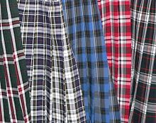 Close up of five skirts in a wide variety of tartans