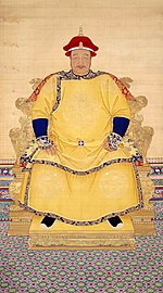 Full-face painted portrait of a corpulent man with a thin mustachio wearing a red hat and a multi-layered yellow robe with dragon decorations, and sitting on a throne mounted on a low podium.