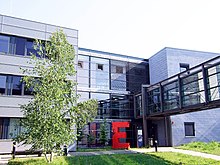 Front of and entrance to the Max Planck Institute for Gravitational Physics in Potsdam-Golm. A large red letter-E sculpture is next to the entrance.