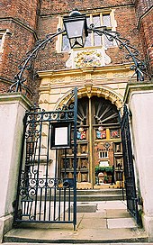 iron-gated entrance to brick-built building with yellow stone doorway