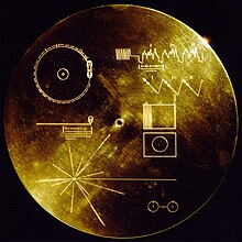 Photograph of a gold phonographic record with images of soundwaves on it