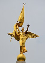 Golden statue of a female angel figure with flag