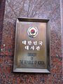 Plaque outside the embassy in English language and Korean depicting the Emblem of South Korea