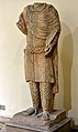 Headless statue of a nobleman features intricate detail.