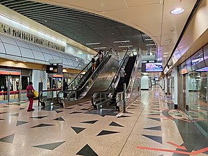 View of the station platforms facing the escalators that connects to the concourse level above the platforms.