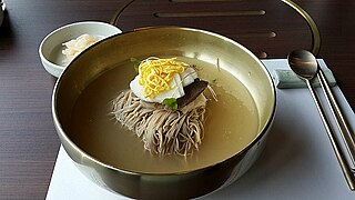 Naengmyeon topped with egg garnish strips