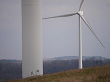 Two turbine of Patton Wind Farm, one of which is so close that only the lower tower is visible in the foreground.