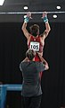 After the gymnast jumped up, the coach assists the gymnast by lifting him up