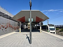 Tiled island platform with train on the right