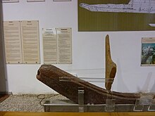 A wooden object on a stand, on display in a museum
