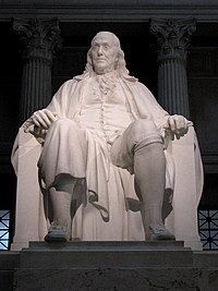Seated statue of Benjamin Franklin in white marble