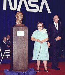Dryden's wife next to a bust of Dryden, Scott by her side
