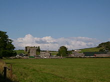 A mixture of old and modern buildings in a field.