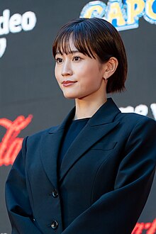 Maeda at press event wearing suit, cropped to head and shoulders portrait