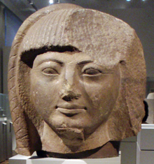 Large head of a statue in light brown stone