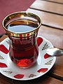 Turkish tea served in a typical small glass and corresponding plate