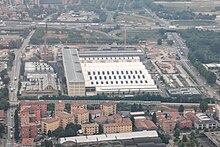An aerial photograph of the ECMWF building in Bologna, surrounded by roads and residential buildings.