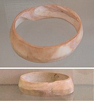 Indus bracelet, front and back, made of Fasciolaria Trapezium or Xandus Pyrum imported to Susa in 2600-1700 BCE. Found in the tell of the Susa acropolis. Louvre Museum, reference Sb 14473.[84] This type of bracelet was manufactured in Mohenjo-daro, Lothal and Balakot.[59] The back is engraved with an oblong chevron design which is typical of shell bangles of the Indus Civilization.[85]