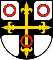 durchgehendes schwarzes Deutschordenskreuz (Heroldsbild), belegt mit einem goldenen Lilienkreuz (gemeine Figur)