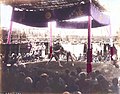 Wrestlers, c. 1886. Hand-coloured albumen print. View of a sumo match showing rikishi [wrestlers], a gyōji [referee] and an audience.