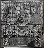 Relief with a pagoda in the centre surrounded by various images of deities. The lower part of the plaque bears an inscription which is framed by two deities.