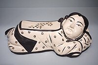 Headrest mould-formed as a girl, Jin dynasty, with overglaze enamels.