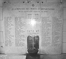 Une plaque en marbre blanc comporte sur quatre colonnes les noms des victimes de l'holocauste