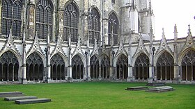 exterior of Gothic cathedral with lawn bounded by single-storey cloister