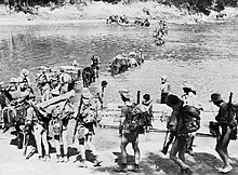 British Chindit Special Forces carrying their weapons and gears advance on a river in Burma.